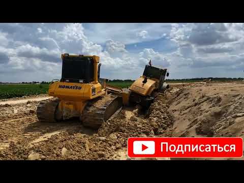 Видео: Дорожный каток утонул в грязи и пришлось выталкивать его бульдозером.