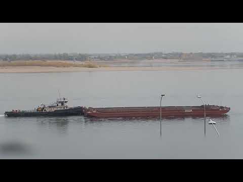 Видео: Две речные несамоходные транспортные баржи транспортируются буксиром-толкачом по реке Волга 2025 год