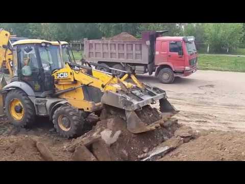 Видео: Погрузка грунта экскаватором-погрузчиком JCB в самосвалы