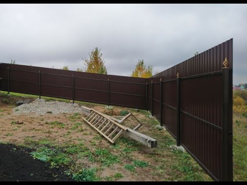 Видео: Забор на склоне из профлиста с декором с помощью электродрели. Какова цена забора, смета.