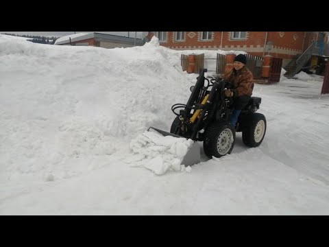 Видео: Убираем  укатанный снег мини погрузчиком ковшом с установленными зубьями