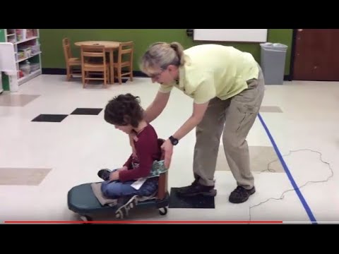 Видео: Контроль головы на скутере: упражнения для ребенка с церебральным параличом # 004