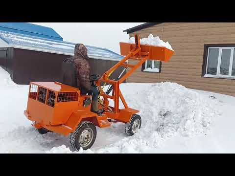 Видео: Уборка снега минипогрузчиком с реверсом и КПП 09