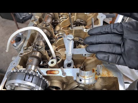 Видео: Использование троса для удержания клапанов при снятии пружины клапана и замене маслосъемного колп...