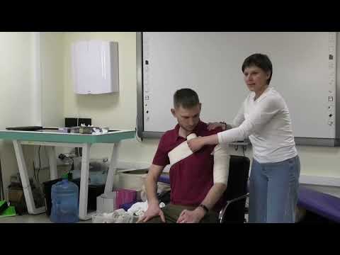 Видео: 24 Фролова ЛП Первая Помощь Колосовидная повязка Иммобилизация плеча