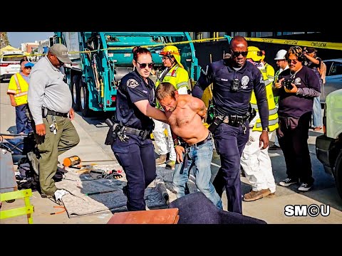 Видео: 𝗗𝗘𝗧𝗘𝗡𝗧𝗜𝗢𝗡 𝗢𝗡 𝗕𝗢𝗔𝗥𝗗𝗪𝗔𝗟𝗞: полиция Лос-Анджелеса надевает наручники на бездомного во время зачистки ...