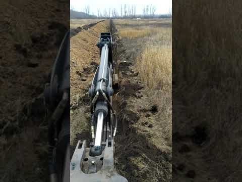Видео: Как выкопать траншею экскаватором погрузчиком