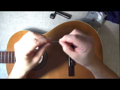 Видео: Как поменять струны на классической гитаре.