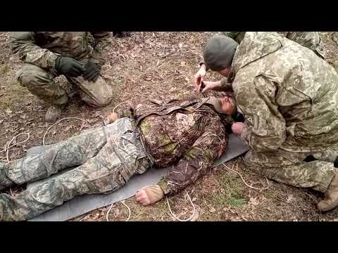 Видео: Иммобилизация и транспортировка пострадавшего с помощью подручных средств из сидушки и коврика.