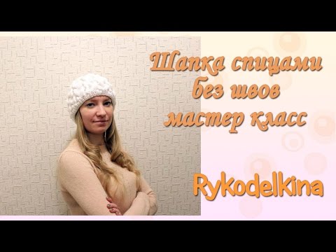 Видео: Вязаная шапка спицами без швов с косами мастер-класс