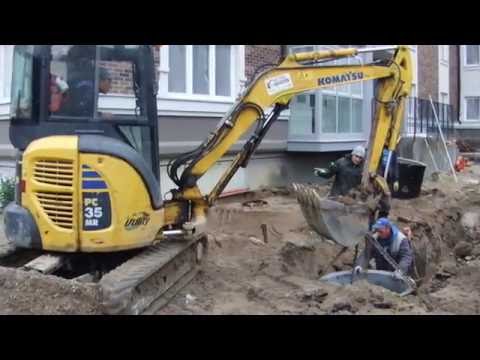Видео: Установка бетонного кольца колодца миниэкскаватором - steh39.ru