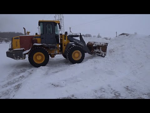 Видео: Чистим снег погрузчиком  (ЗАСТРЯЛИ В СНЕГУ )