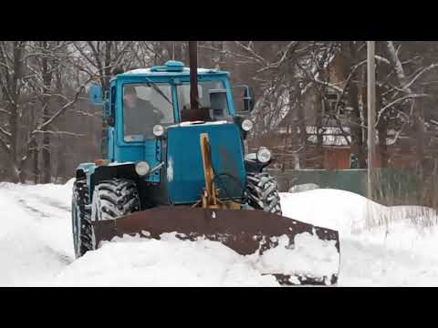 Видео: Трактор Т-150 чистит дорогу по улице в деревне