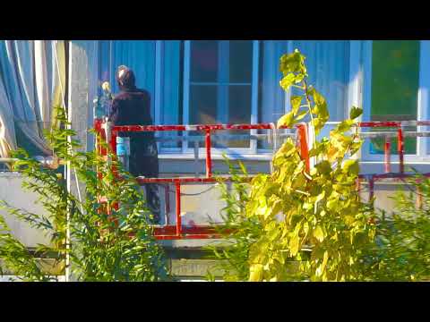 Видео: Рабочие строители отделывают утеплителем фасад жилого дома октябрь 2025 года
